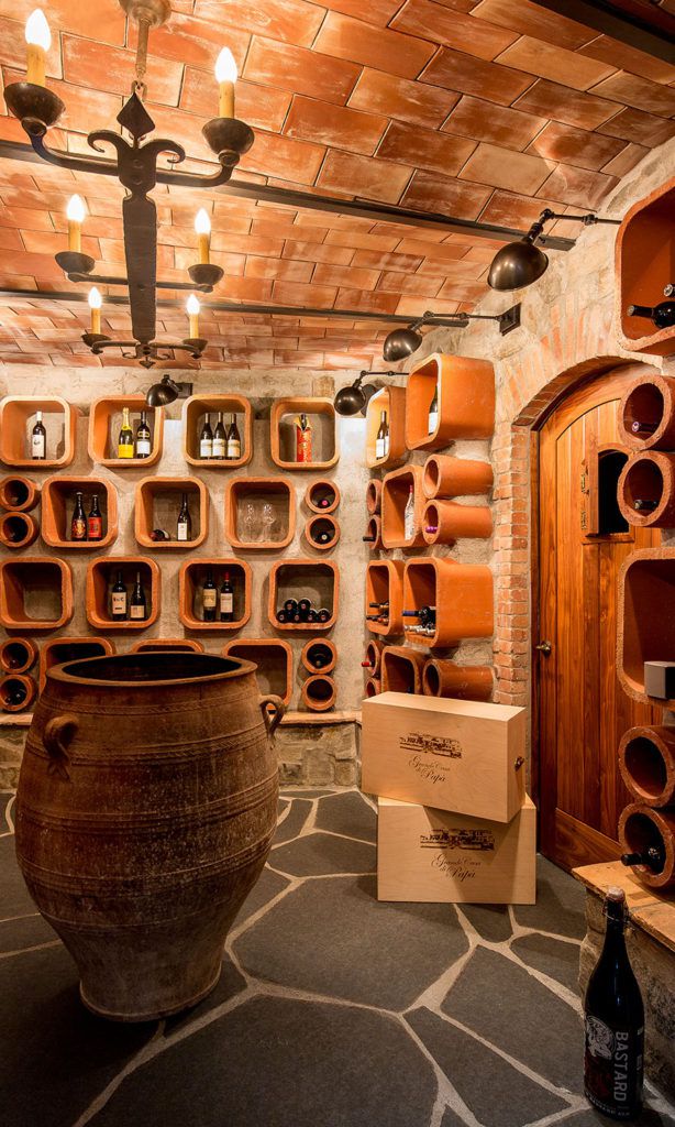 Tuscan style architecture finds beauty in imperfection, like this custom home wine cellar.